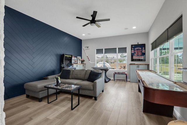living area featuring recessed lighting, an accent wall, light wood-type flooring, and a ceiling fan