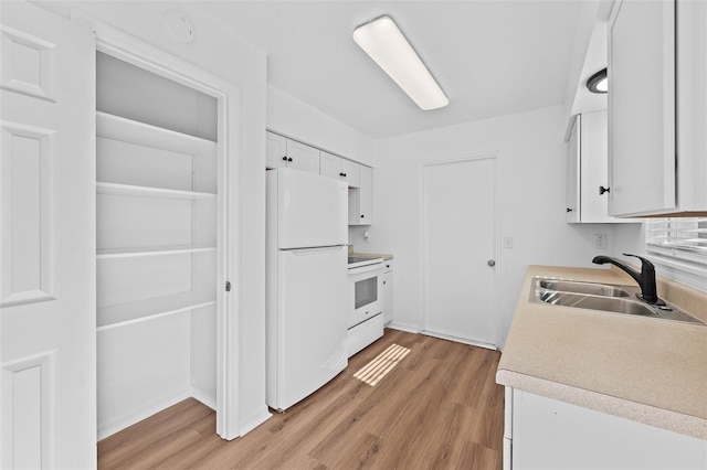 kitchen with white cabinetry, sink, white appliances, and light wood-type flooring