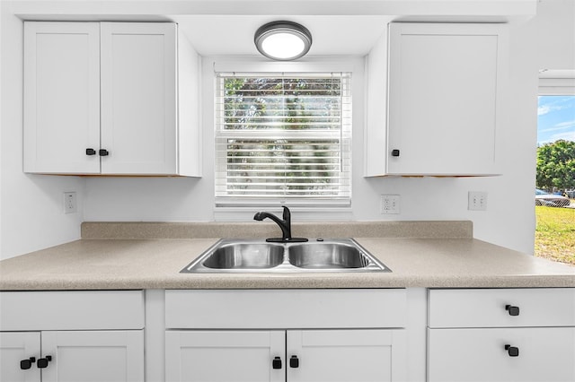 kitchen with a healthy amount of sunlight, sink, and white cabinets