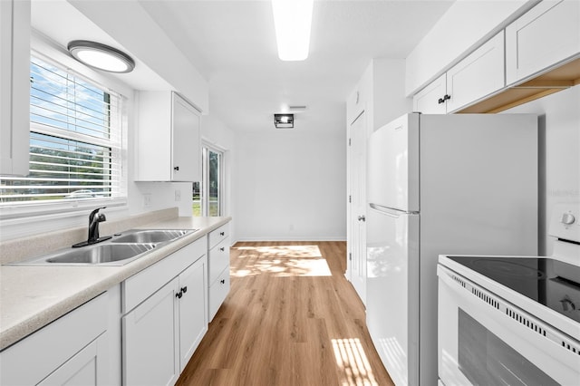 kitchen featuring white electric stove, sink, white cabinets, and light wood-type flooring