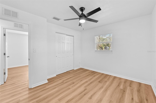 unfurnished bedroom with ceiling fan, a closet, and light wood-type flooring