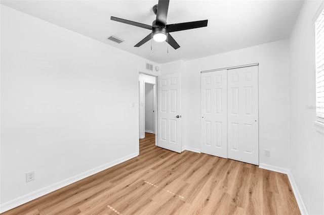 unfurnished bedroom featuring ceiling fan, light hardwood / wood-style floors, and a closet