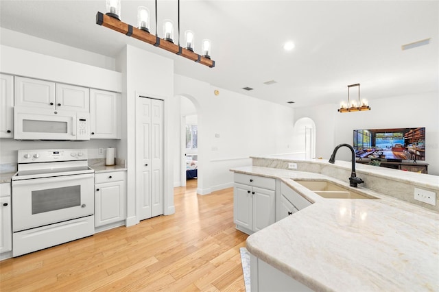 kitchen with sink, white cabinetry, hanging light fixtures, white appliances, and light hardwood / wood-style floors