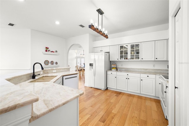 kitchen featuring sink, decorative light fixtures, kitchen peninsula, white appliances, and white cabinets