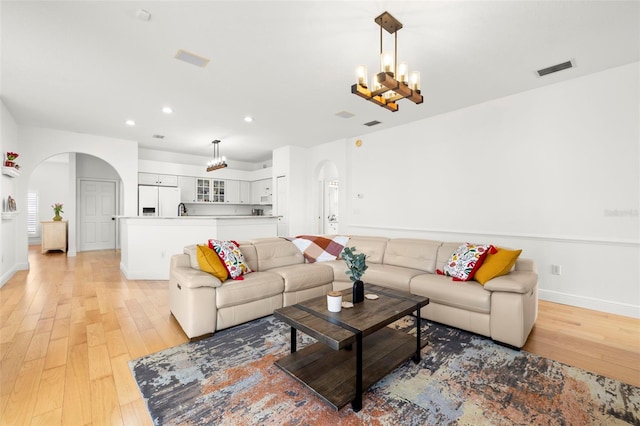 living room featuring a chandelier and light wood-type flooring