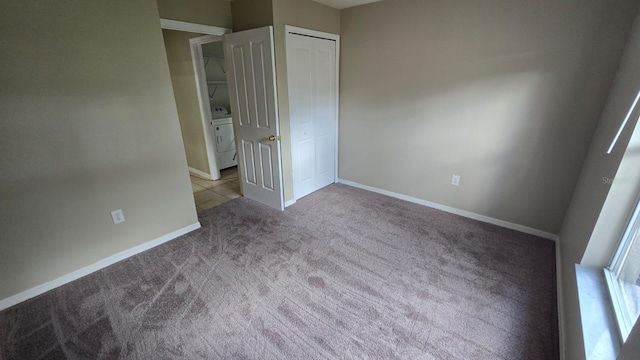 unfurnished bedroom with light carpet, washer / dryer, and a closet