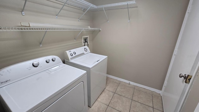 laundry room with washing machine and dryer and light tile patterned floors