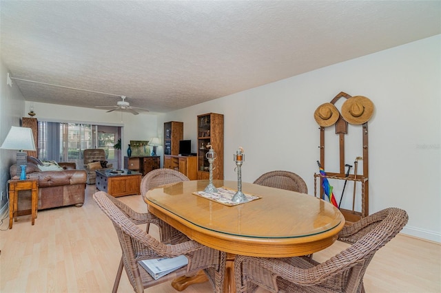 dining room featuring ceiling fan, a textured ceiling, and light wood-type flooring