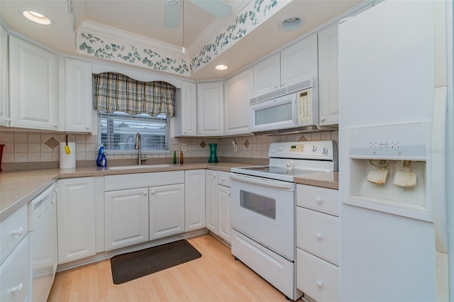 kitchen with sink, white cabinetry, crown molding, white appliances, and light hardwood / wood-style floors