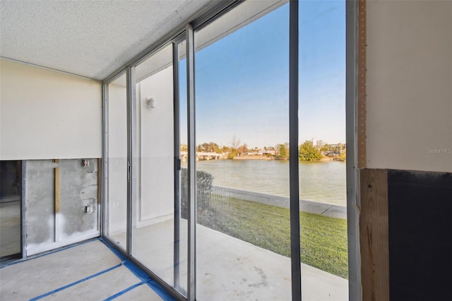 doorway to outside featuring a textured ceiling and a water view