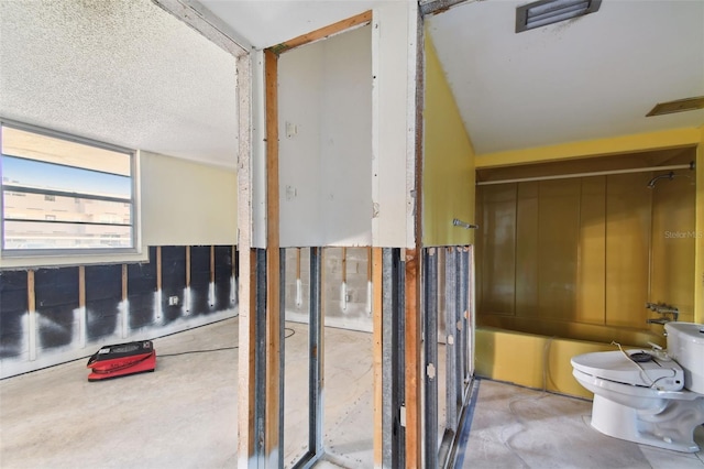 bathroom featuring concrete floors, a textured ceiling, and toilet