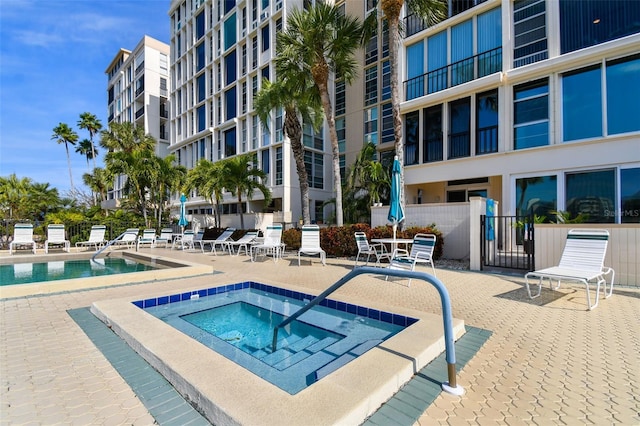 view of swimming pool featuring a patio and a community hot tub