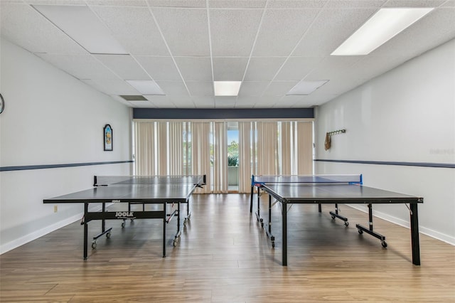 game room featuring hardwood / wood-style floors and a drop ceiling