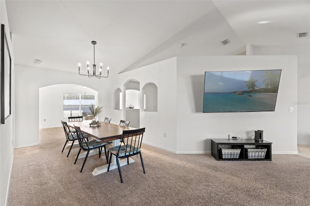 carpeted dining room with lofted ceiling and a chandelier