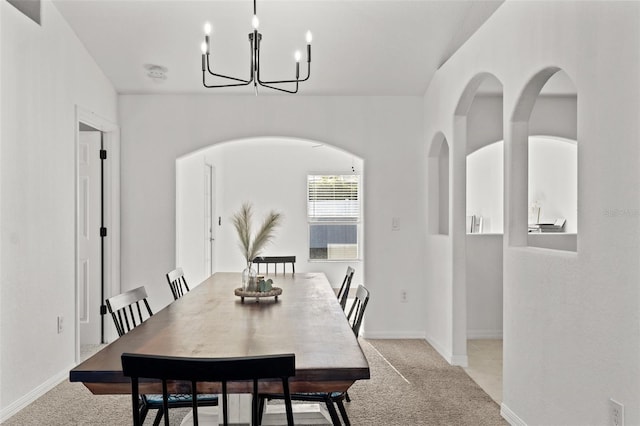 carpeted dining space featuring a chandelier