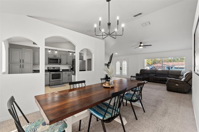 dining space with vaulted ceiling and light colored carpet