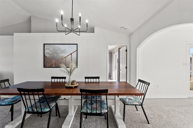 dining area with lofted ceiling, carpet floors, and a notable chandelier