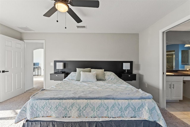 carpeted bedroom featuring connected bathroom and ceiling fan