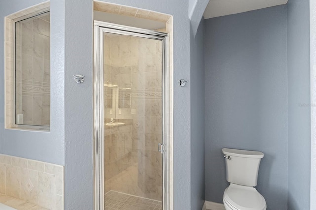 bathroom with toilet and a shower with shower door