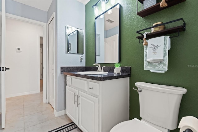 bathroom featuring vanity, tile patterned floors, and toilet