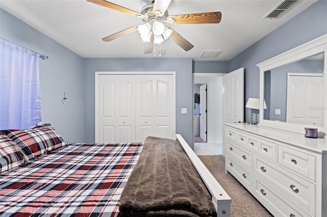 carpeted bedroom with ceiling fan and a closet