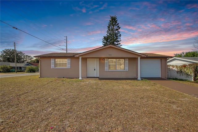 ranch-style home with a garage and a yard