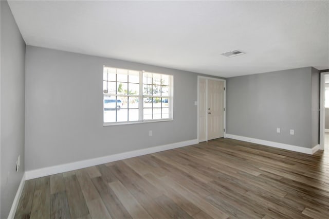 empty room with dark hardwood / wood-style flooring