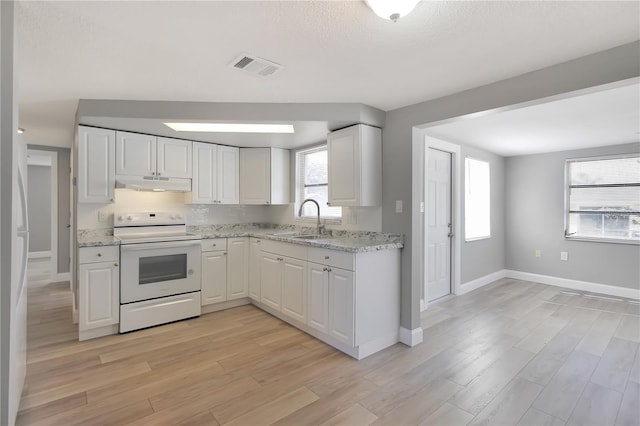 kitchen featuring sink, white electric range oven, light stone counters, light hardwood / wood-style floors, and white cabinets