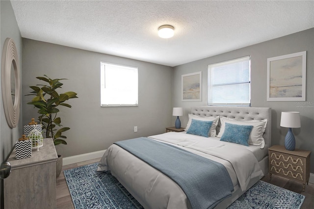 bedroom with dark hardwood / wood-style flooring and a textured ceiling