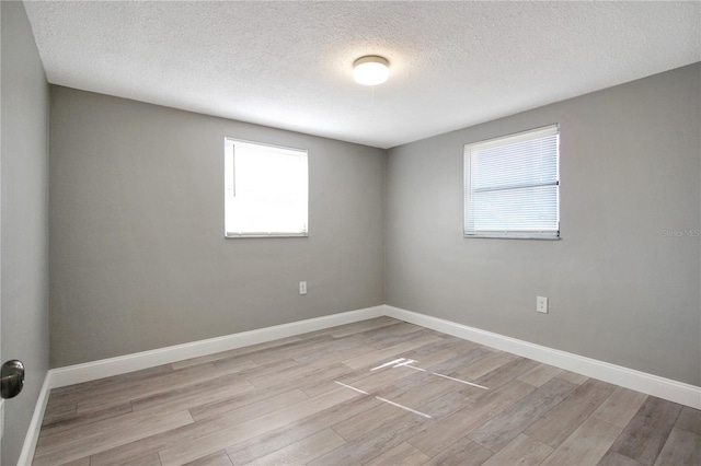 empty room featuring light hardwood / wood-style floors and a textured ceiling