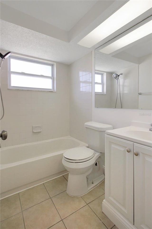 full bathroom with tiled shower / bath, a healthy amount of sunlight, toilet, and tile patterned flooring