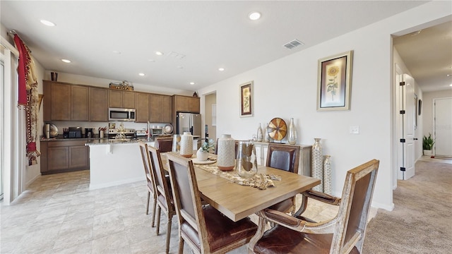 dining area featuring light colored carpet