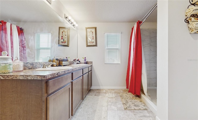 bathroom with vanity, curtained shower, and a textured ceiling