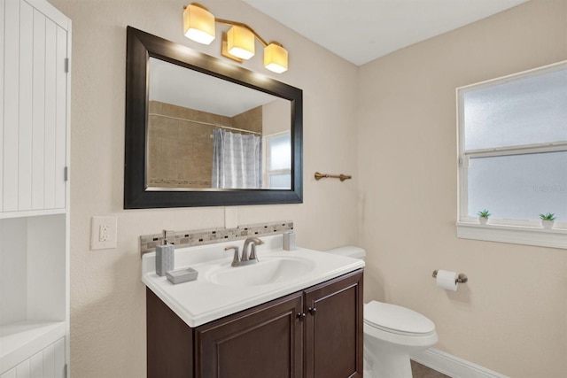 bathroom featuring a shower with curtain, vanity, and toilet