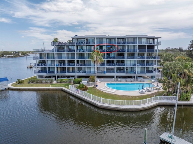 view of property with a community pool and a water view