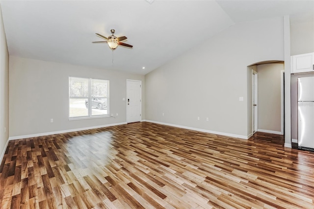 unfurnished living room featuring lofted ceiling, ceiling fan, and light hardwood / wood-style flooring