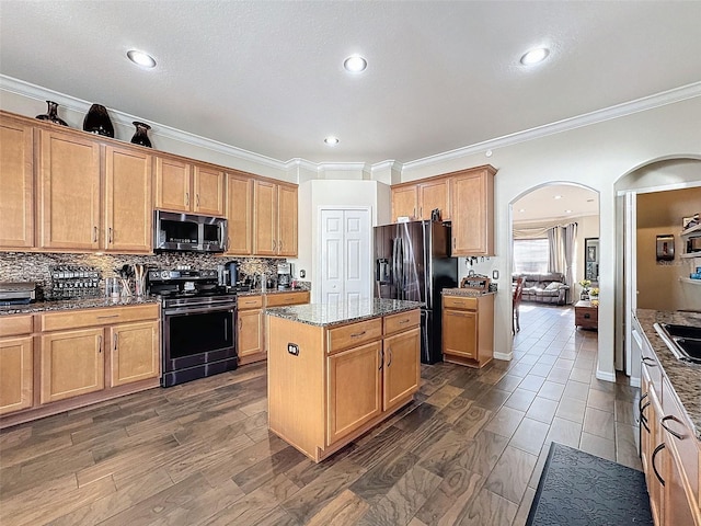 kitchen featuring a kitchen island, dark stone countertops, backsplash, ornamental molding, and stainless steel appliances