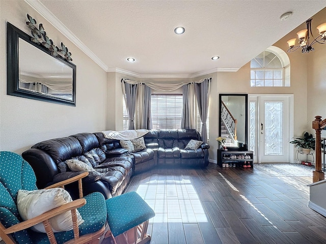 living room featuring an inviting chandelier, wood-type flooring, crown molding, and a textured ceiling