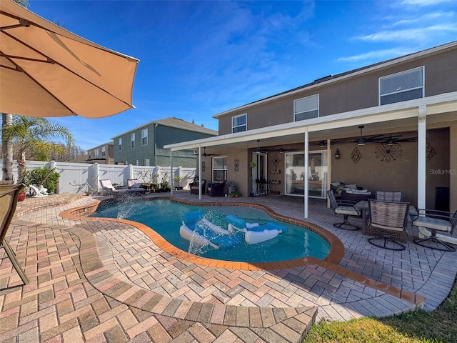 view of pool with pool water feature, ceiling fan, and a patio area