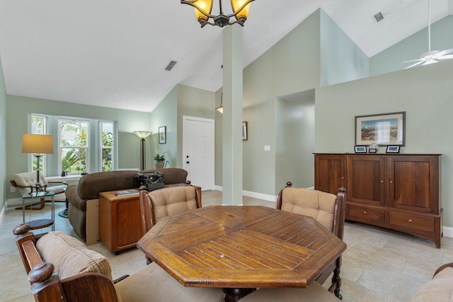 dining room featuring light tile patterned flooring, ceiling fan with notable chandelier, and high vaulted ceiling