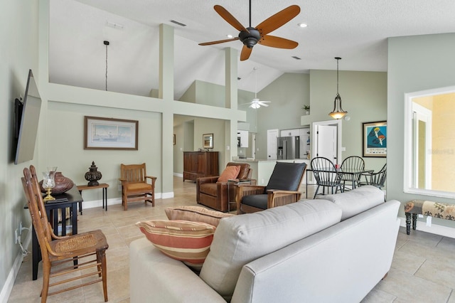 tiled living room with ceiling fan and high vaulted ceiling