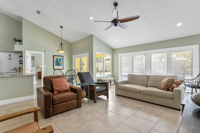 living room featuring ceiling fan, high vaulted ceiling, a textured ceiling, and light tile patterned floors