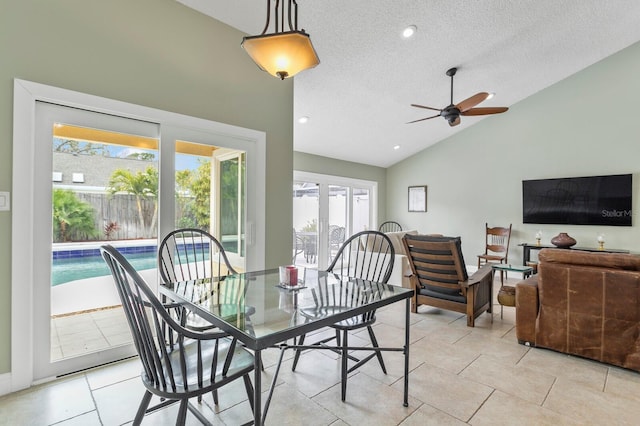 tiled dining room with ceiling fan, vaulted ceiling, and a textured ceiling