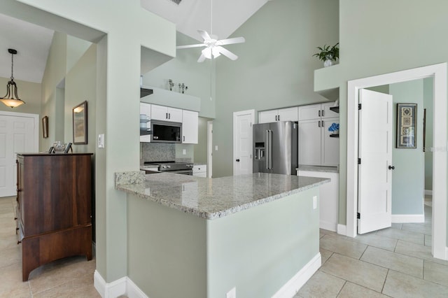 kitchen featuring light stone counters, appliances with stainless steel finishes, decorative light fixtures, and white cabinets