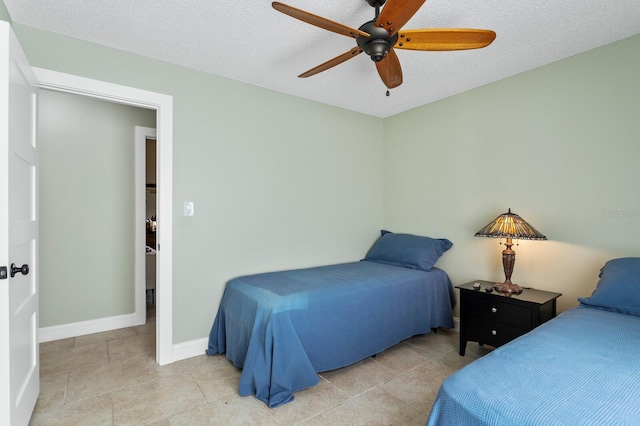 bedroom with ceiling fan and a textured ceiling