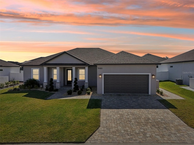 prairie-style home featuring a garage and a lawn