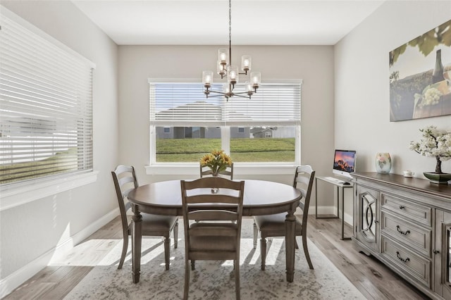 dining room with a wealth of natural light, a notable chandelier, and light hardwood / wood-style flooring