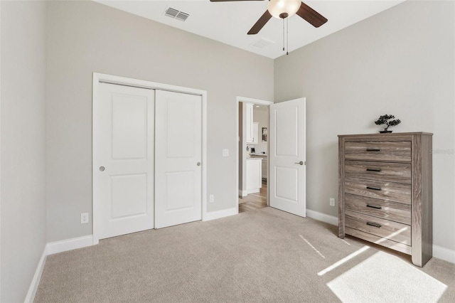 unfurnished bedroom with light carpet, a closet, and ceiling fan