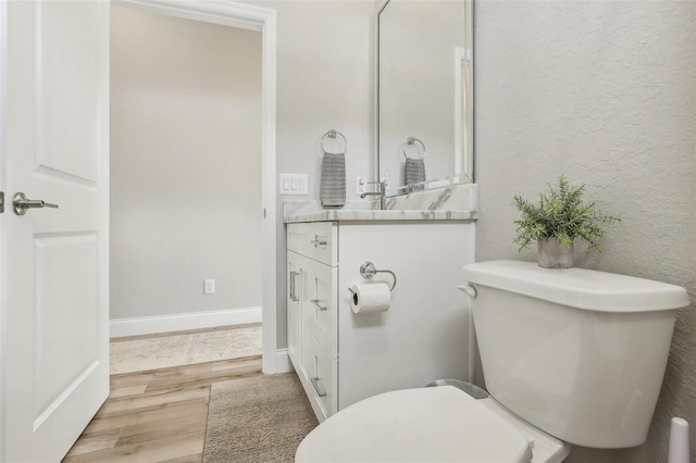 bathroom with hardwood / wood-style flooring, vanity, and toilet