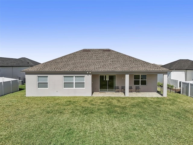 back of property with a lawn and a patio